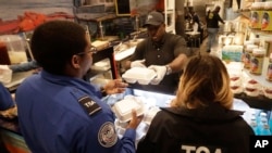 Chef Creole owner Wilkinson Sejour hands out free hot meals to TSA workers at his restaurant at Miami International Airport, Jan. 15, 2019, in Miami. 