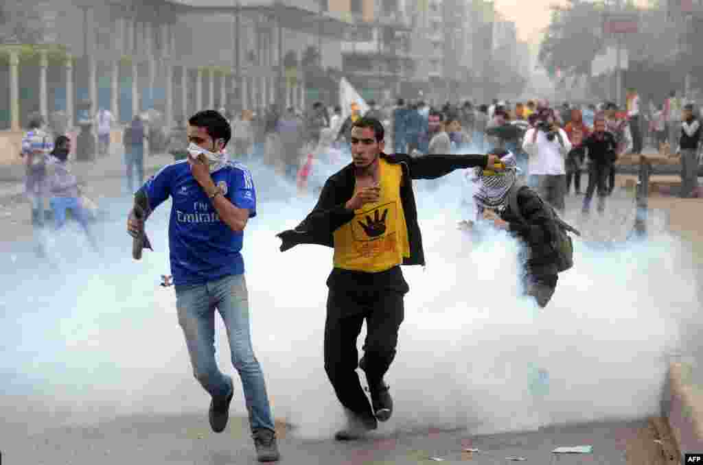 Supporters of ousted president Mohamed Morsi and the Muslim brotherhood run away from tear gas during clashes with Egyptian riot police close to Rabaa al-Adawiya Square. 