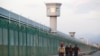 FILE PHOTO: Workers walk by the perimeter fence of what is officially known as a vocational skills education center in Dabancheng in Xinjiang Uighur Autonomous Region, China,Sept. 4, 2018. 