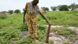 A government soldier inspects a rocket found after recent clashes with rebels in Kuek, northern Upper Nile state, South Sudan, Aug. 19, 2017.