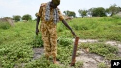 A government soldier inspects a rocket found after recent clashes with rebels in Kuek, northern Upper Nile state, South Sudan, Aug. 19, 2017.