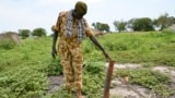 FILE: A government soldier inspects a rocket found after recent clashes with rebels in Kuek, northern Upper Nile state, South Sudan, Aug. 19, 2017.