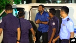 Sheikh Imran Abdulla, leader of the Islamic conservative Adhaalath Party, or Justice Party, is escorted to court in Male, Maldives, May 2, 2015.