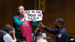 An anti-war activist shouts in protest as Secretary of State Antony Blinken and Defense Secretary Lloyd Austin speak to the Senate Appropriations Committee at the Capitol in Washington, Oct. 31, 2023.