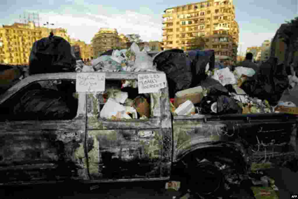 A burnt out car in which Egyptians are depositing garbage is seen in Tahrir Square in Cairo, Egypt, Monday, Jan. 31, 2011. A coalition of opposition groups called for a million people to take to Cairo's streets Tuesday to demand the removal of President H