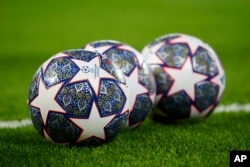 FILE - The Official UEFA Champions League match balls lie on the pitch ahead of the Champions League, round of 16, first leg football match between Liverpool and Real Madrid at the Anfield stadium in Liverpool, England, on Feb. 21, 2023.