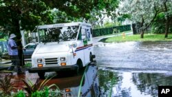 FILE - A postal truck is parked on a flooded street a few miles from downtown Miami, June 19, 2019. Some consider Miami ground zero for any climate-related sea level rise in the United States. 