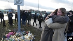 La gente se reúne en un monumento improvisado cerca de la escena de un tiroteo en las afueras de Orebro, Suecia, el 5 de febrero de 2025.