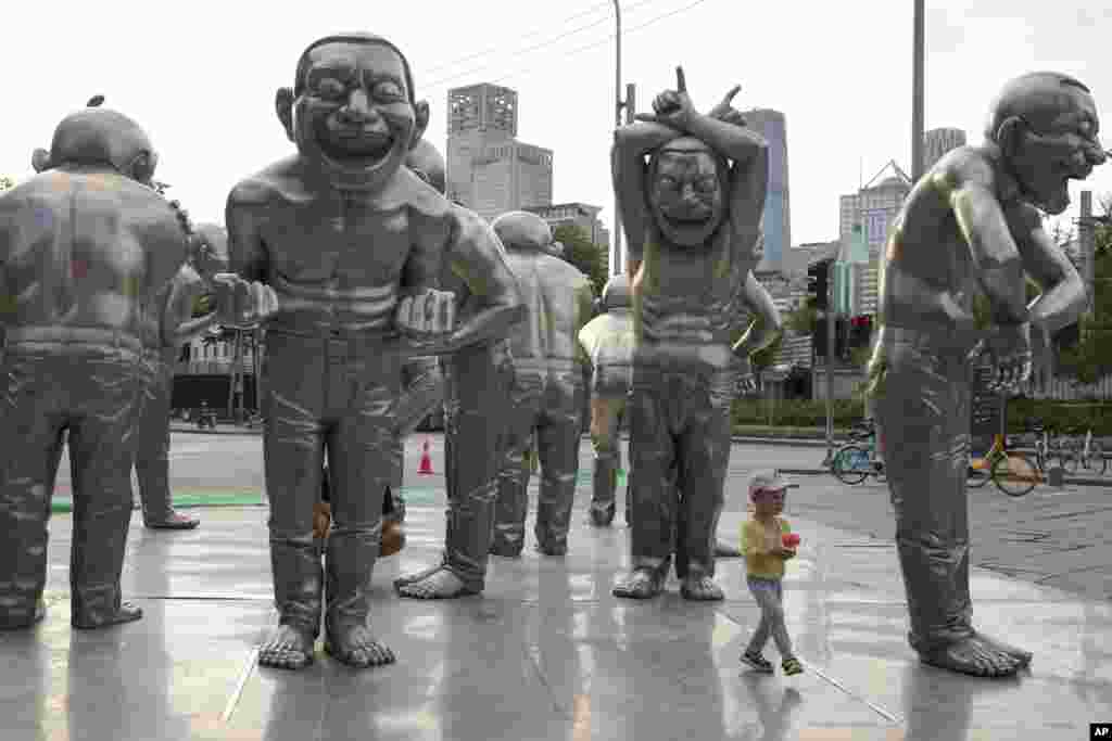 A child plays around sculptures outside a residential area in Beijing, China, June 5, 2021.