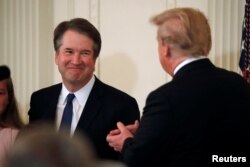 Supreme Court nominee Judge Brett Kavanaugh smiles next to U.S. President Donald Trump in the East Room of the White House in Washington, July 9, 2018
