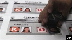 A worker inspects electoral ballots with images of presidential candidates in Lima, Peru, May 4, 2011