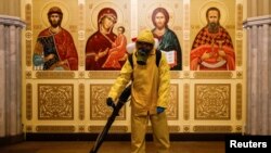 A specialist wearing personal protective equipment (PPE) sprays disinfectant while sanitizing a chapel inside the building of the Leningradsky railway station amid the outbreak of the coronavirus disease (COVID-19) in Moscow, Russia October 19, 2021. 