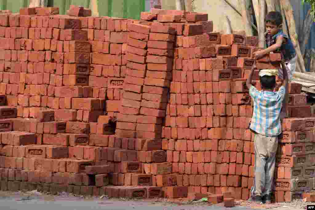 This photograph shows children loading bricks at a building site in New Delhi.