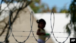 FILE - A child plays at a camp for asylum seekers stuck on America's doorstep, in Matamoros, Mexico, Nov. 18, 2020. 