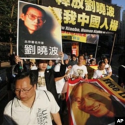 Pro-democracy protesters with banners bearing photos of jailed Chinese dissident Liu Xiaobo march to the Chinese government liaison office in Hong Kong, 05 Dec 2010