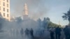 Tear gas floats in the air as a line of law enforcement personnel move demonstrators and media away from St. John's Church at Lafayette Park across from the White House, during a George Floyd protest, in Washington, June 1, 2020.