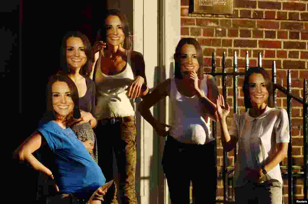 Women pretending to be pregnant and wearing masks of Britain's Catherine, Duchess of Cambridge pose outside the Lindo Wing of St Mary's Hospital, where the Duchess of Cambridge is expected to give birth, in London July 18, 2013.