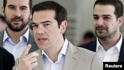 FILE - Greek Prime Minister Alexis Tsipras gestures during his visit at the Ministry of Culture, Education and Religious Affairs in Athens.