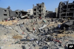 Warga Palestina berkeliaran di antara puing-puing bangunan yang menjadi sasaran serangan udara Israel di kamp pengungsi Jabaliya, Jalur Gaza utara, Rabu, 1 November 2023. (Foto: AP)
