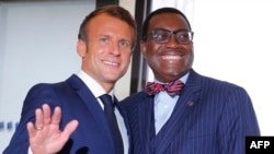 French President Emmanuel Macron, left, welcomes African Development Bank president Akinwumi Adesina upon his arrival in Biarritz, France, Aug. 25, 2019.