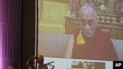 South African Archbishop Desmond Tutu, sitting at left, speaks during a live video link with Tibetan spiritual leader the Dalai Lama, on screen, near the city of Cape Town, South Africa, October 8, 2011.