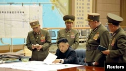 North Korean leader Kim Jong Un (C) presides over an urgent operation meeting on the Korean People's Army Strategic Rocket Force's performance of duty for firepower strike, at the Supreme Command in Pyongyang, March 29, 2013.