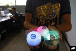 Examples of a remote-controlled ball toy called Sphero is held by an employee at Sphero in Boulder, Colorado, July 24, 2015.
