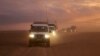 (FILE) A convoy of vehicles of the Syrian Arab Red Crescent driving in the Syrian desert heading to Rukban camp in Nov. 2018.