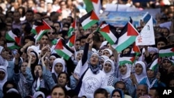 Palestinians wave flags during a rally in support of the Palestinian bid for statehood recognition in the United Nations, in the West Bank city of Ramallah, Sept. 21, 2011.