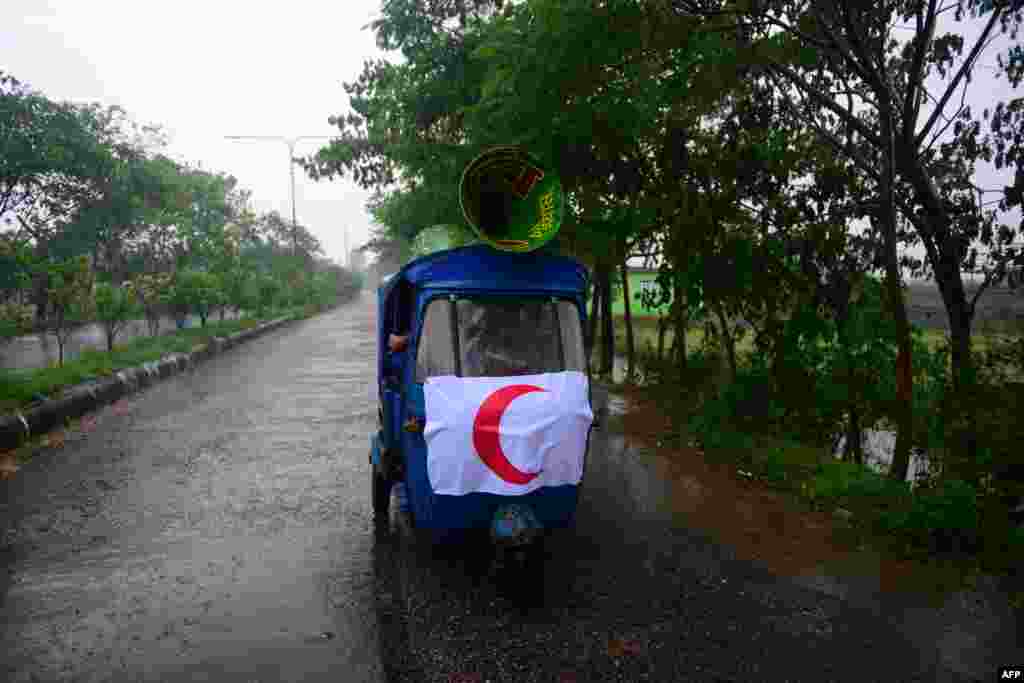 Bangladeshi Red Crescent Society members announce evacuation orders using loudspeakers on top of an auto-rickshaw as Cyclone Mahasen heads toward Chittagong.