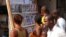 FILE - People read news headlines at a newsstand in Conakry, March 28, 2014. 