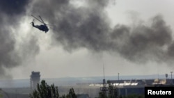 Un helicóptero Mi-24 ucraniano dispara contra posiciones rebeldes en el aeropuerto de Donetsk.