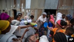 FILE - Displaced Tigrayans queue to receive food donated by local residents at a reception center for the internally displaced in Mekele, in the Tigray region of northern Ethiopia, May 9, 2021. 