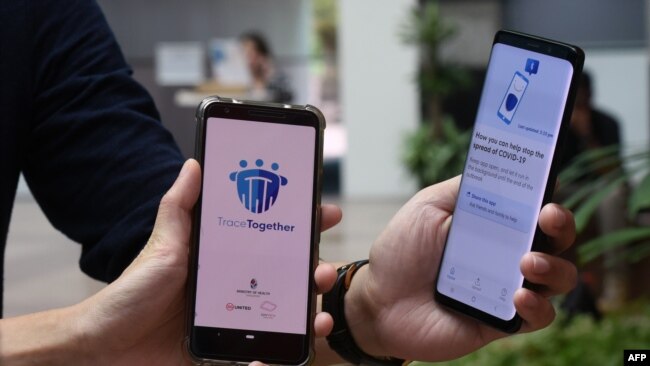 Government Technology Agency staff demonstrate Singapore's new contact-tracing smarthphone app called TraceTogether, as a preventive measure against the coronavirus in Singapore on March 20, 2020.