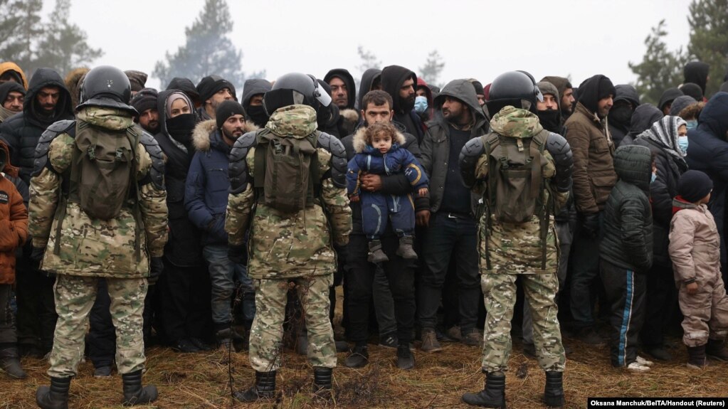 白俄罗斯军人在白俄罗斯-波兰边境的一个临时营地守卫，移民正聚集在一起等待领取人道主义援助物资。（2021年11月14日）(photo:VOA)