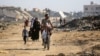 Gazzeliler, El Burayj kampında yıkılan binaların arasından geçerken- 2 Haziran 2024.