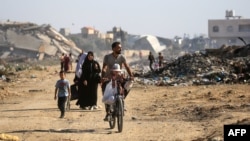 Palestinians use a path lined with destroyed buildings al-Bureij camp in the central Gaza Strip on June 2, 2024.