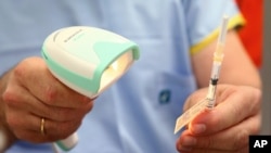 FILE - A vial of the Pfizer vaccine is scanned before being administered at the Royal Prince Alfred Hospital Vaccination Hub in Sydney, Australia, Feb. 22, 2021.