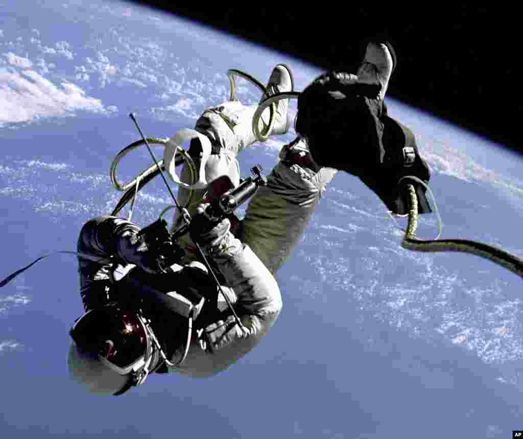 1965 Edward H. White II, pilot of the Gemini 4 spacecraft, floats in the zero gravity of space with an earth limb backdrop. This represents the first time an American has stepped outside the confines of his spacecraft. White is attached to the spacecraft