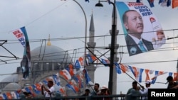 A banner of Turkish President Tayyip Erdogan and Turkey's ruling AK Party (AKP) flags hang over Galata bridge in Istanbul,, June 10, 2018. 