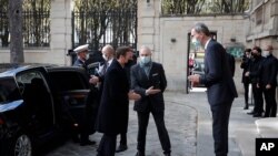 French President Emmanuel Macron, left, is welcomed by Deputy Head of Mission at the Austrian embassy Wolfgang Wagner in Paris before signing a condolence book for victims of the Vienna attack, Nov. 3 2020.