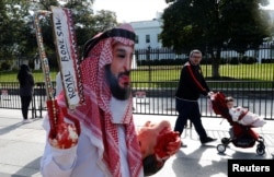 FILE- An activist dressed as Saudi Crown Prince Mohammad bin Salman marches in front the White House as another man pushes his child past in a stroller during a demonstration calling for sanctions against Saudi Arabia after the disappearance of Saudi journalist Jamal Khashoggi, in Washington, Oct. 19, 2018. It was determined that Khashoggi was killed Oct. 2 at the Saudi Consulate in Istanbul.