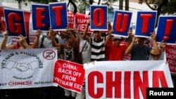 Filipino activists and Vietnamese nationals display placards and chant anti-China slogans as they march outside the Chinese Consulate in Manila's Makati financial district, May 16, 2014.