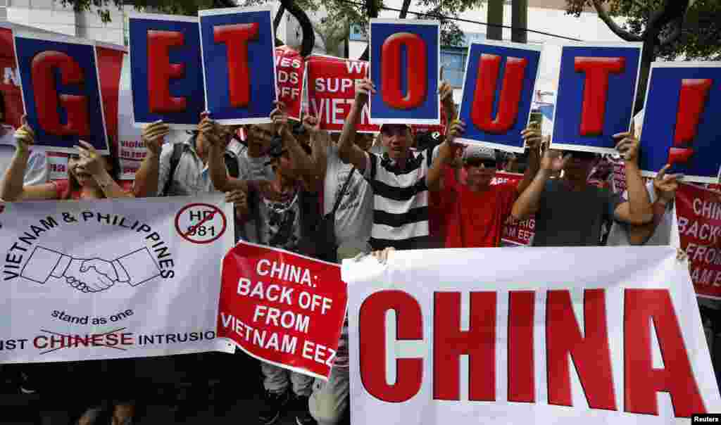 Philippine activists and Vietnamese nationals display placards and chant anti-China slogans as they march outside the Chinese consulate in Manila&#39;s Makati financial district, May 16, 2014.