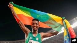 Selemon Barega wa Ethiopia akishangilia na bendera ya nchi yake baada ya kutwaa medali ya dhahbu mita 10000.