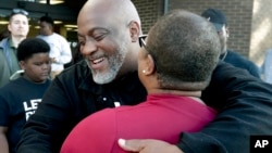 Former felon Desmond Meade and president of the Florida Rights Restoration Coalition, left, hugs Melanie Campbell with the National Coalition Black Civic Participation, after registering to vote on Jan. 8, 2019, in Orlando, Fla.