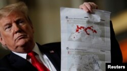 President Donald Trump shows maps of Syria and Iraq depicting the size of the "ISIS physical caliphate" as he speaks to workers at the country's only remaining tank manufacturing plant, in Lima, Ohio, March 20, 2019. 