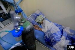 A wounded Yemeni schoolgirl lies on a bed as she receives treatment at a hospital in the capital Sanaa on April 7, 2019, following a blast that killed several civilians including students in Yemen's capital.