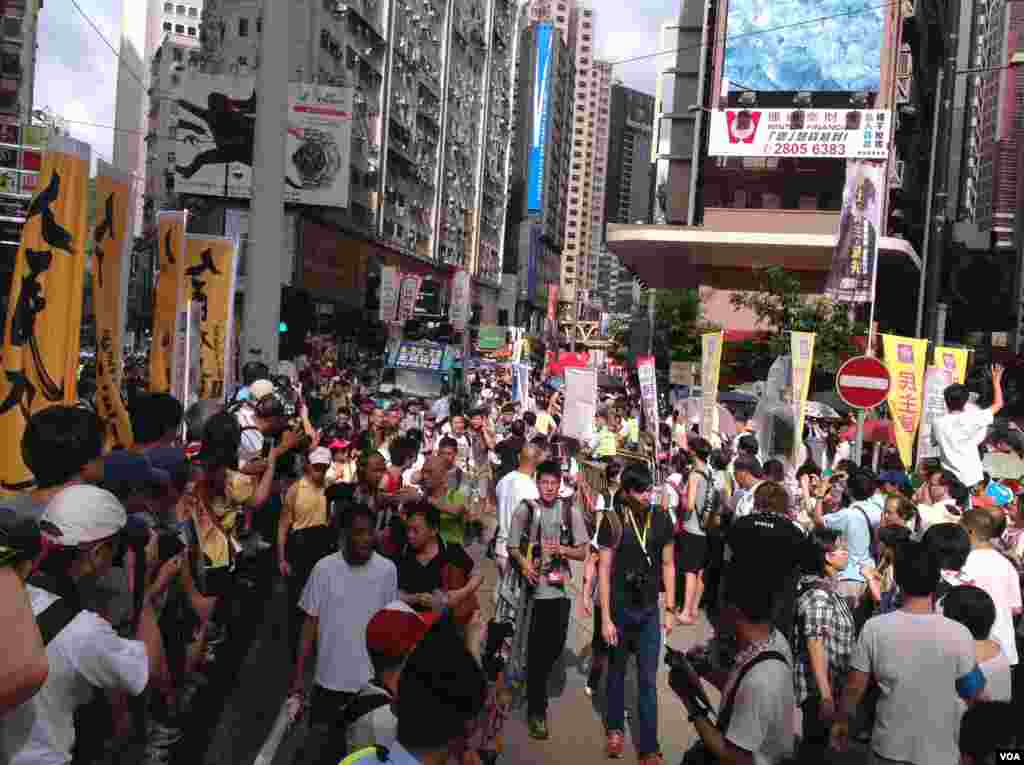 今天是香港回归17周年纪念日，在官方和亲北京团体举行各种庆祝活动的同时，几十万市民下午冒着高温走上街头，参加七一大游行(美国之音海彦拍摄)