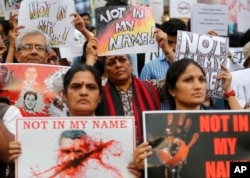 Participants hold placards during a protest against a spate of violent attacks across the country targeting the country's Muslim minority, in Bangalore, India, June 28, 2017.